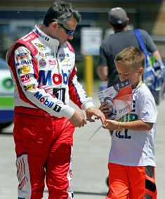 Tony Stewart takes some time to autograph a hero card for a race fan.(Photo Credit: HHP Photo/Alan Marler)