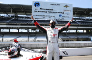 Andretti proudly holds his NTT P1 Award check above his head on pit lane Sunday. (Credit: Chris Jones/IndyCar Media)