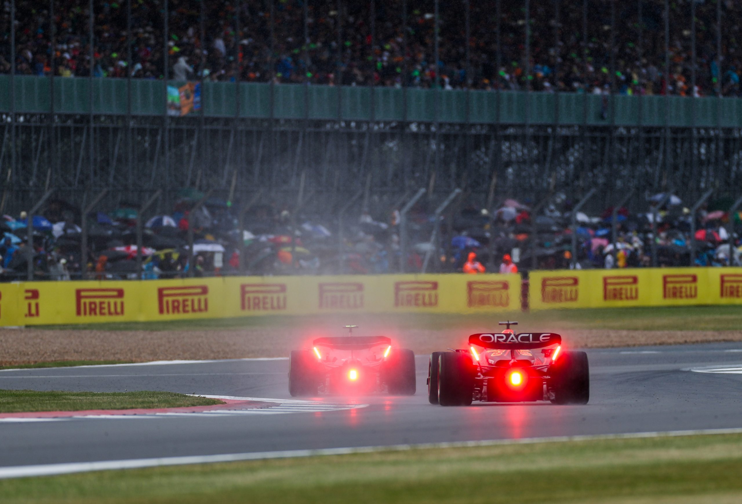 Max Verstappen (1) follows in his Red Bull Lewis Hamilton (44) in his Mercedes in the rain during the final practice at Silverstone Circuit.