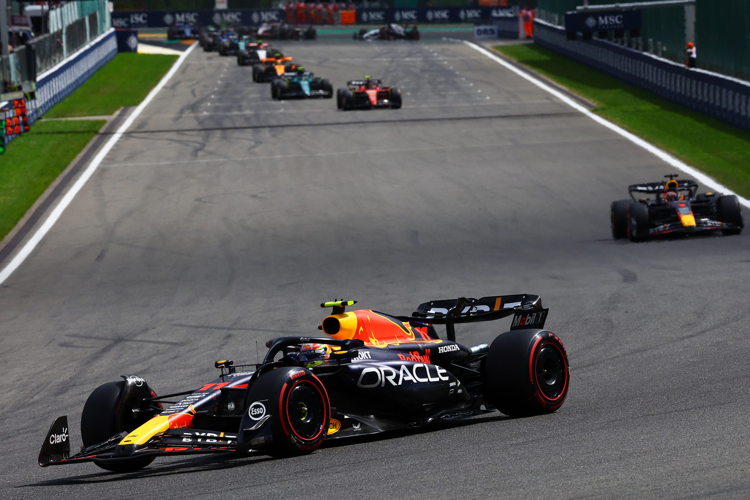 Sergio Perez (11) leads the way in his Red Bull in the early laps of the Belgian Grand Prix