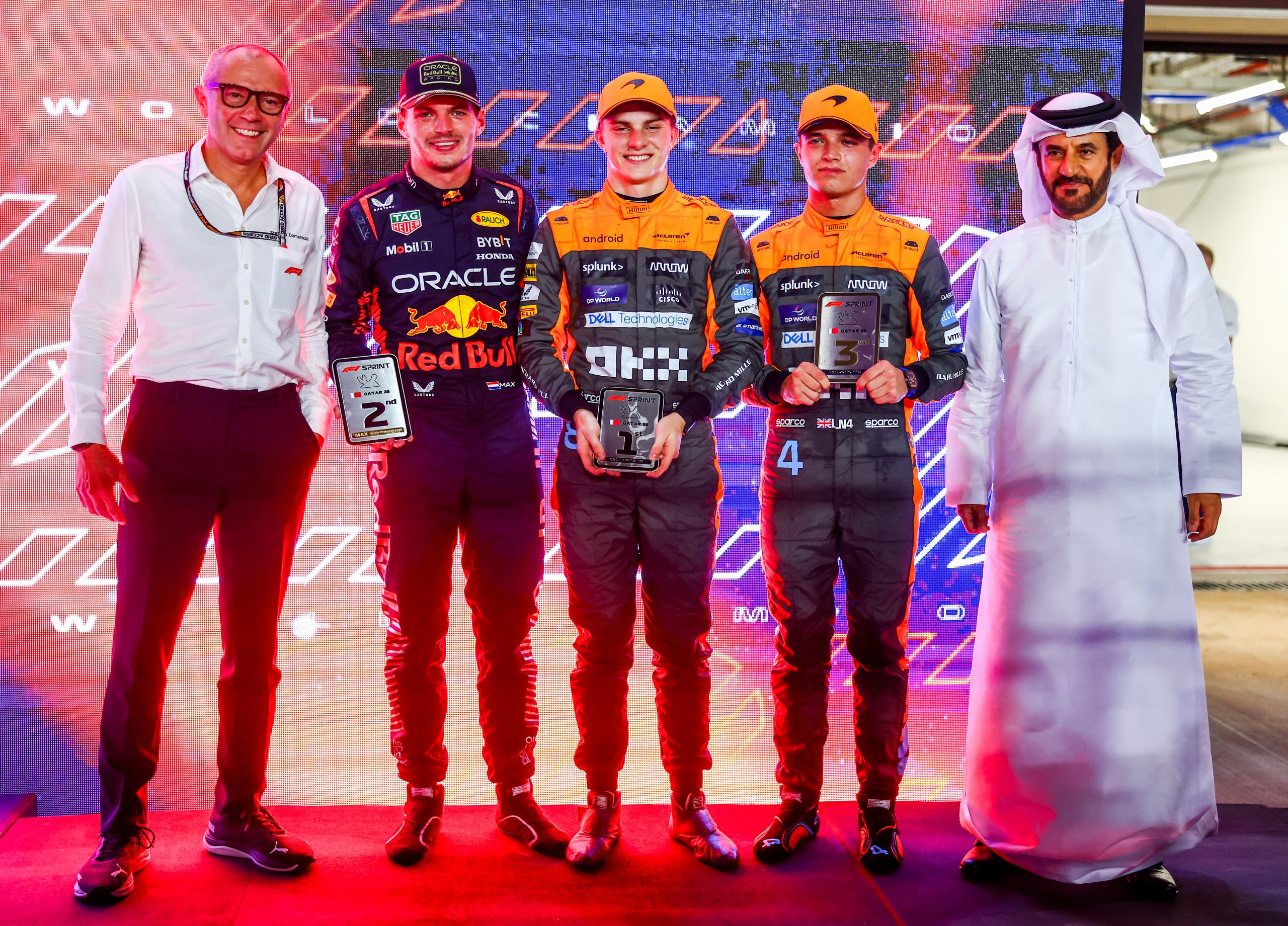 Sprint winner Oscar Piastri of Australia and McLaren, 2nd placed Max Verstappen of the Netherlands and Oracle Red Bull Racing and third placed Lando Norris of Great Britain and McLaren pose for a photo with their trophies and Stefano Domenicali, CEO of the Formula One Group, and Mohammed ben Sulayem, FIA President, in parc ferme after the Sprint ahead of the F1 Grand Prix of Qatar at Lusail International Circuit on October 07, 2023 in Lusail City, Qatar. (Photo by Mark Thompson/Getty Images)